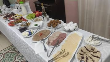 Uma mesa de buffet com diversos alimentos e utensílios.