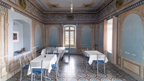 Un comedor con piso estampado, mesas y sillas blancas.