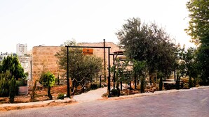 Un jardín con un letrero que dice 'Jardín' y un camino que lleva a un edificio.