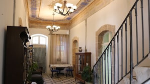 Una habitación amplia con comedor, escalera y candelabro.