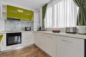 Departamento Confort | Cocina privada | Refrigerador con congelador, microondas, horno y cafetera y tetera 