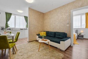 Una sala de estar moderna con un sofá, una mesa de centro y un comedor con sillas y una mesa.