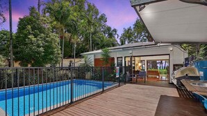 A pool area with a wooden deck, a barbecue setup, and a covered seating area. - Onda Beach Holiday Home in Clifton Beach (Clifton Beach)