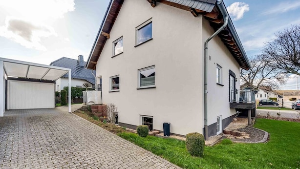 A two-story house with a paved driveway, a covered garage, and a well-maintained lawn. - Tranquil Getaway in Scenic Roes (Roes)
