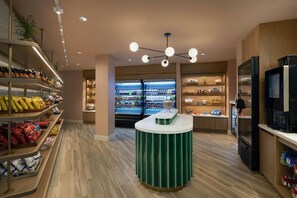 A modern retail space with shelves stocked with snacks and beverages, a central counter, and a refrigerated display in the background. - The Perfect Place to Stay! Close to Miami Art Museum, Pet Friendly, Free Shuttle (Miami)