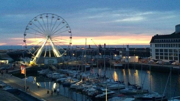 A waterfront marina with a large Ferris wheel in the background. - Drakkar - Fecamp - City Break (FECAMP)