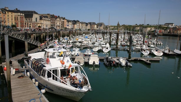 A marina with boats docked, a bridge, and buildings in the background. - Les Amants de Saint Jean (DIEPPE)