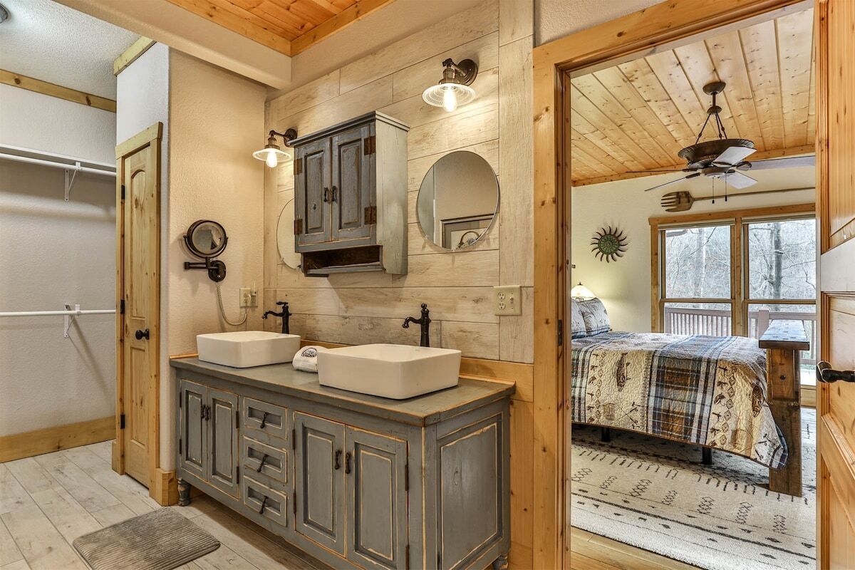 A bathroom with two sinks, a mirror, and a cabinet.