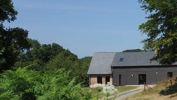 Un bâtiment moderne doté d’un toit en pente et d’une petite fenêtre.