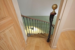 Staircase leads to a landing with a light-colored wall and wooden floor.