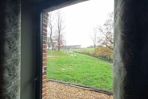 Enjoy a serene view of the lush outdoors from the comfort of your room, with a large window framing the natural scenery.