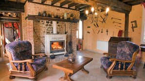 Une pièce chaleureuse avec une cheminée en pierre, des meubles en bois et un lustre.