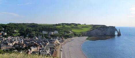 A coastal town with a beach, houses, and cliffs.