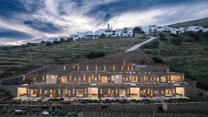 A modern villa with multiple bedrooms, a large outdoor area, and a view of a hillside village. - Ivy's Natural Resort (Tinos)