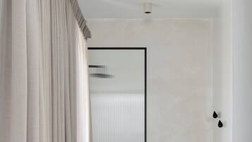 A modern bathroom with a freestanding bathtub, a glass shower enclosure, and a curtain.