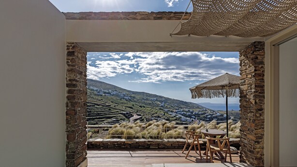 A pool area with a view of a village and mountains. - Ivy's Natural Resort (Tinos)
