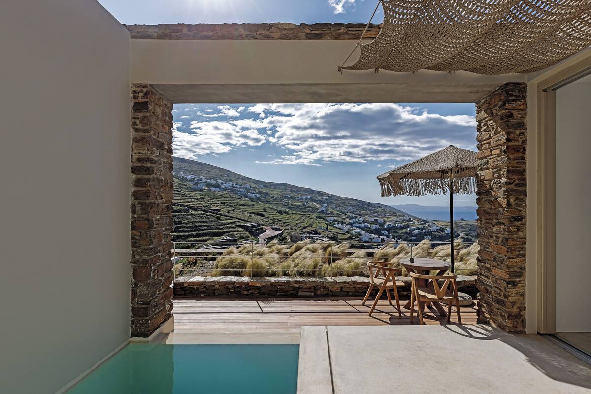 Zona de piscina con vistas a un pueblo y montañas.