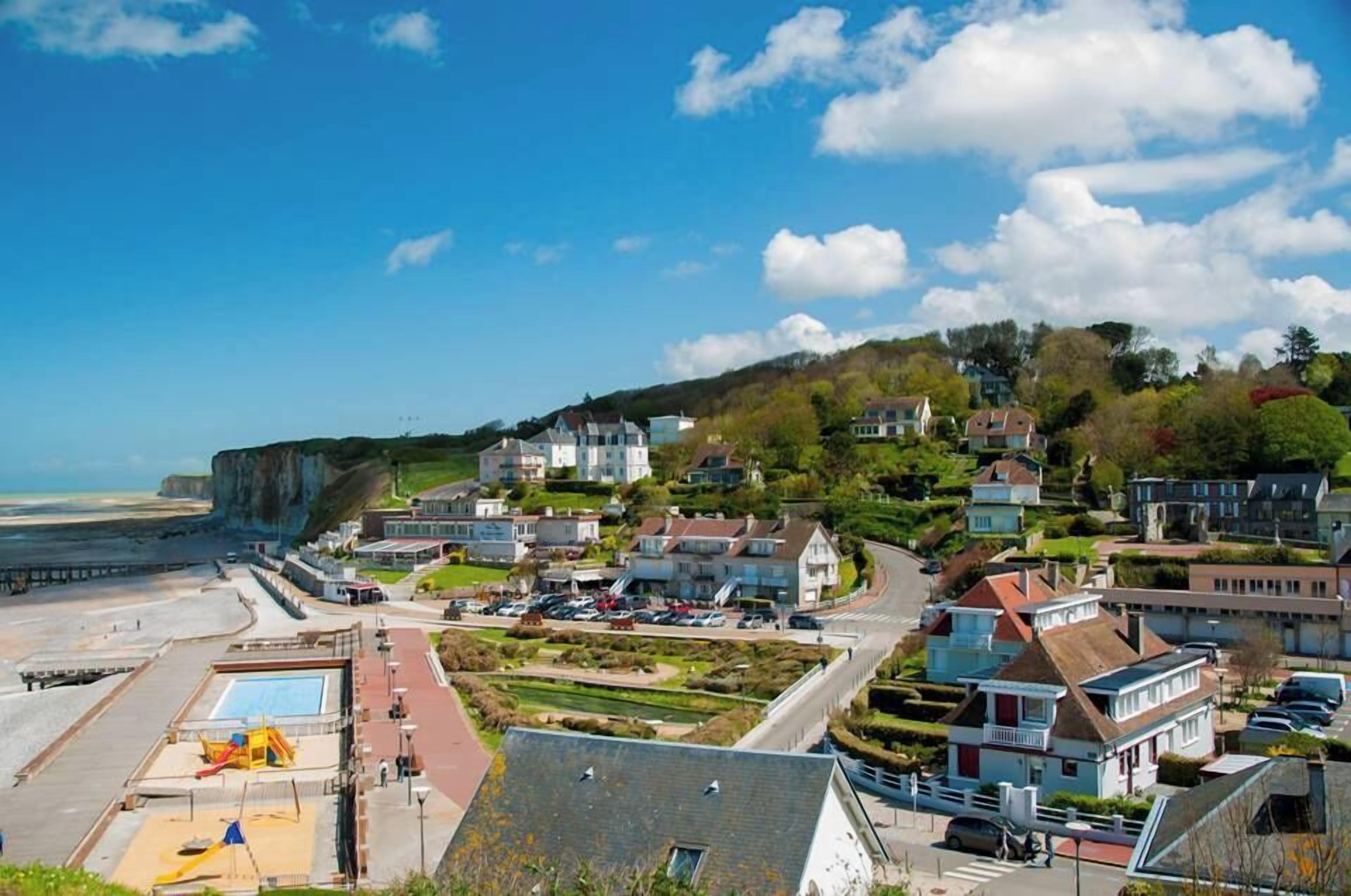 Une ville côtière avec des maisons, une plage et des falaises.