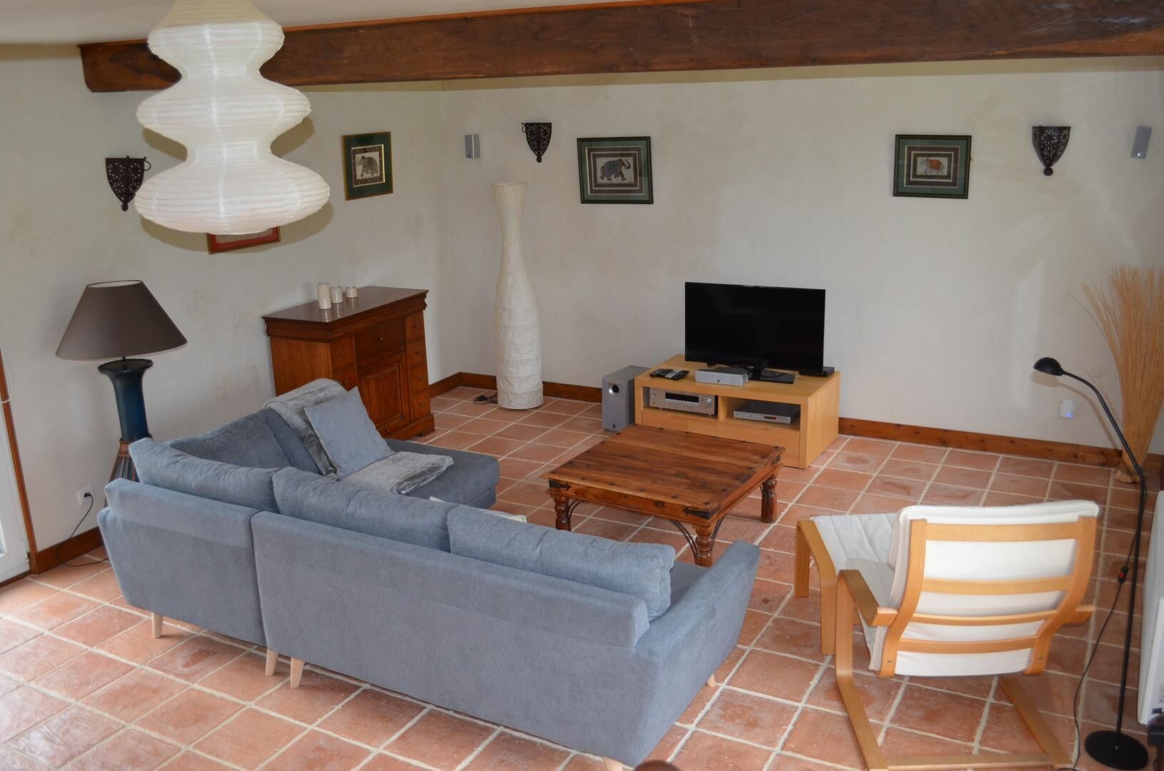 A living room with a sofa, a coffee table, a TV stand, and a chair.