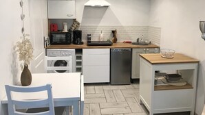 A compact kitchen with white cabinetry, a microwave, a coffee maker, and a dishwasher. - Le Clos Saint-martin (AVESNES EN BRAY)