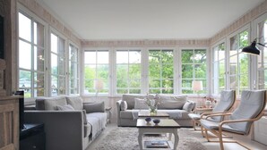 A spacious living room with a large window, a sofa, a coffee table, and two armchairs. - Le Doris - Vattetot SUR MER (VATTETOT SUR MER)