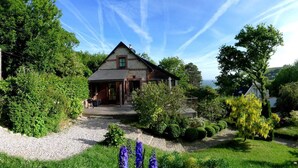 A house with a sloped roof, surrounded by lush greenery and a gravel driveway. - Le Doris - Vattetot SUR MER (VATTETOT SUR MER)