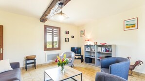 A living room with a sofa, armchairs, a coffee table, a TV, and a bookshelf. - Le Bremontier - Massy (MASSY)