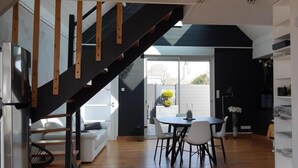 Eine moderne Küche mit Essbereich, einer Treppe und Ausblick nach draußen.