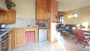 A compact kitchen with wooden cabinets, a built-in stove, and a dishwasher.