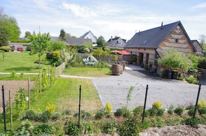 A rural property with a fenced garden, a wooden play structure, and a brick building with a sloped roof. - Pomme Cannelle - ST Jouin Bruneval (ST JOUIN BRUNEVAL)