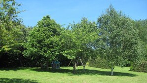 A grassy outdoor area with trees and a small structure. - Rose - Bourg DUN (BOURG DUN (LE))