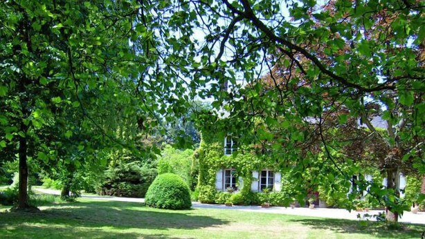 A well-maintained garden with a neatly trimmed lawn, a variety of shrubs, and a building with a classic architectural style. - Le Verger - Varneville Bretteville (VARNEVILLE BRETTEVILLE)