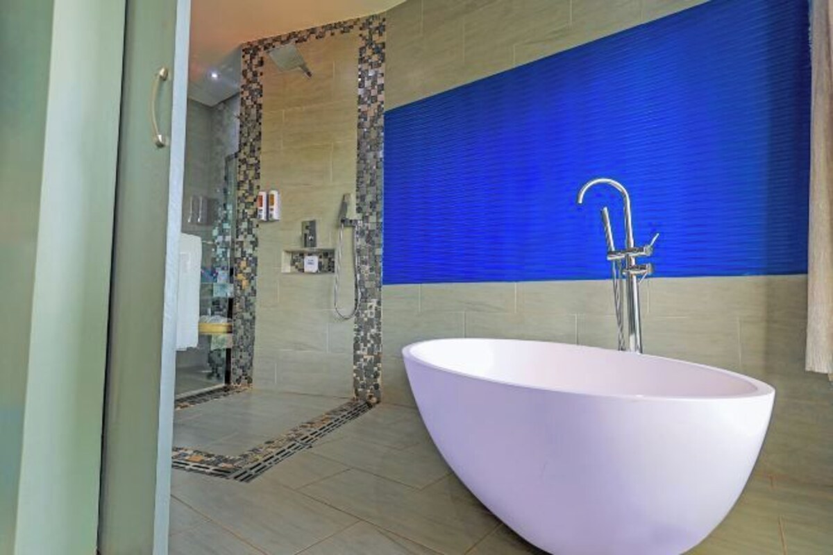 A modern bathroom with a freestanding bathtub, a shower area, and a tiled floor.