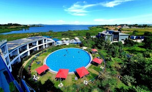 A resort with a central swimming pool, sun loungers, and a view of the sea. - Aquarius Kigo Resort  (Kampala)