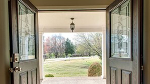 A wooden front door with glass panels and a doormat. - Private Hot Tub, Porch Fireplace, Large Yard (Franklin)