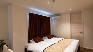 A hotel room with a large bed, a bedside table, a chair, and a plant. - Oyado Nishishichijo (Kyoto)