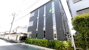 A modern two-story building with a dark facade and multiple windows. - Oyado Nishishichijo (Kyoto)