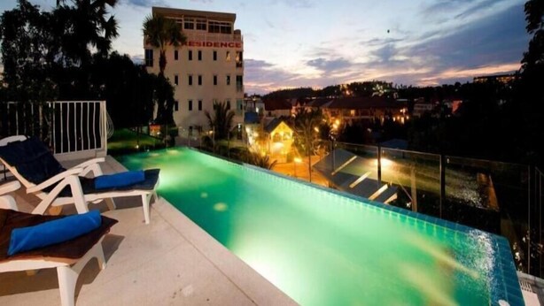 A swimming pool with lounge chairs and a building labeled "RESIDENCE" in the background. - LaXenia (Karon)