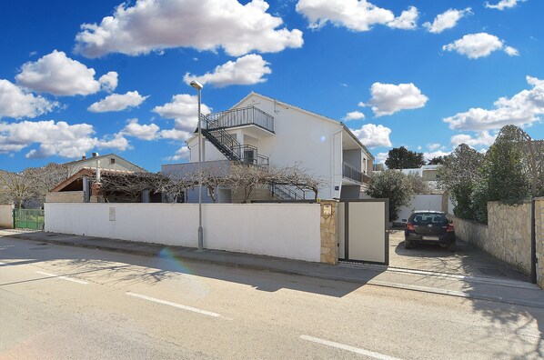 A two-story house with a staircase leading to the upper floor, a fenced yard, and a parked car in the background. - Apartment 2221/66969 (Istria - Medulin), 900m from the beach (Medulin)