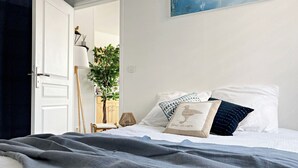 Ein Schlafzimmer mit Bett, Kissen, einer Lampe und einem Bild an der Wand.