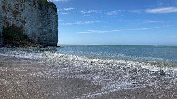 Ein Strand mit weißen Klippen und ruhigem Meer.