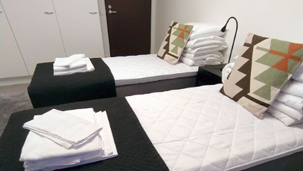 A hotel room with two beds, each with a pillow and a folded towel. - Kuukkeli Sodankylä Apartments (Sodankyla)
