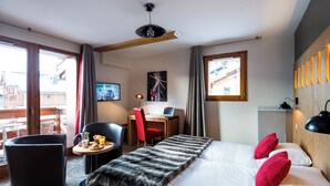 A hotel room with a bed, a desk, a chair, a small table with breakfast, and a TV. - Lagrange Vacances Les Chalets D'emeraude (Hauteluce)
