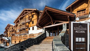 A wooden chalet-style building with a stone staircase leading to a wooden door labeled 'ACCUEIL.' - Lagrange Vacances Les Chalets D'emeraude (Hauteluce)