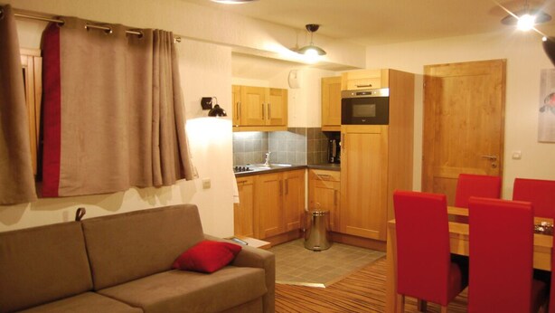 A compact living space with a kitchenette, a sofa, and a dining area. - Lagrange Vacances Les Chalets D'emeraude (Hauteluce)