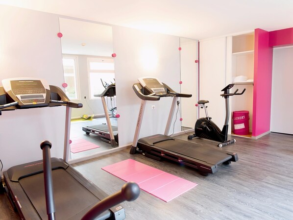 A home gym with treadmills, an elliptical, and a stationary bike. - Logis Hôtel de France Restaurant le Lucullus (Montmorillon)