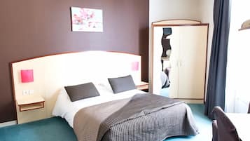 Ein Hotelzimmer mit Bett, Nachttischen, einem Kleiderschrank und einem Bild an der Wand.