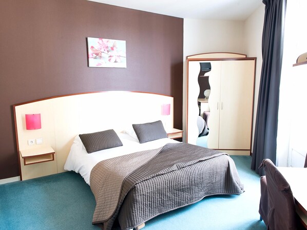 A hotel room with a bed, bedside tables, a wardrobe, and a painting on the wall. - Logis Hôtel de France Restaurant le Lucullus (Montmorillon)