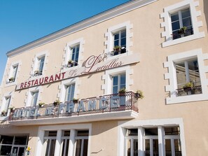 Un edificio con un letrero que dice 'RESTAURANT Le Lucullus' y 'HOTEL DE FRANCE', indicando un establecimiento francés.