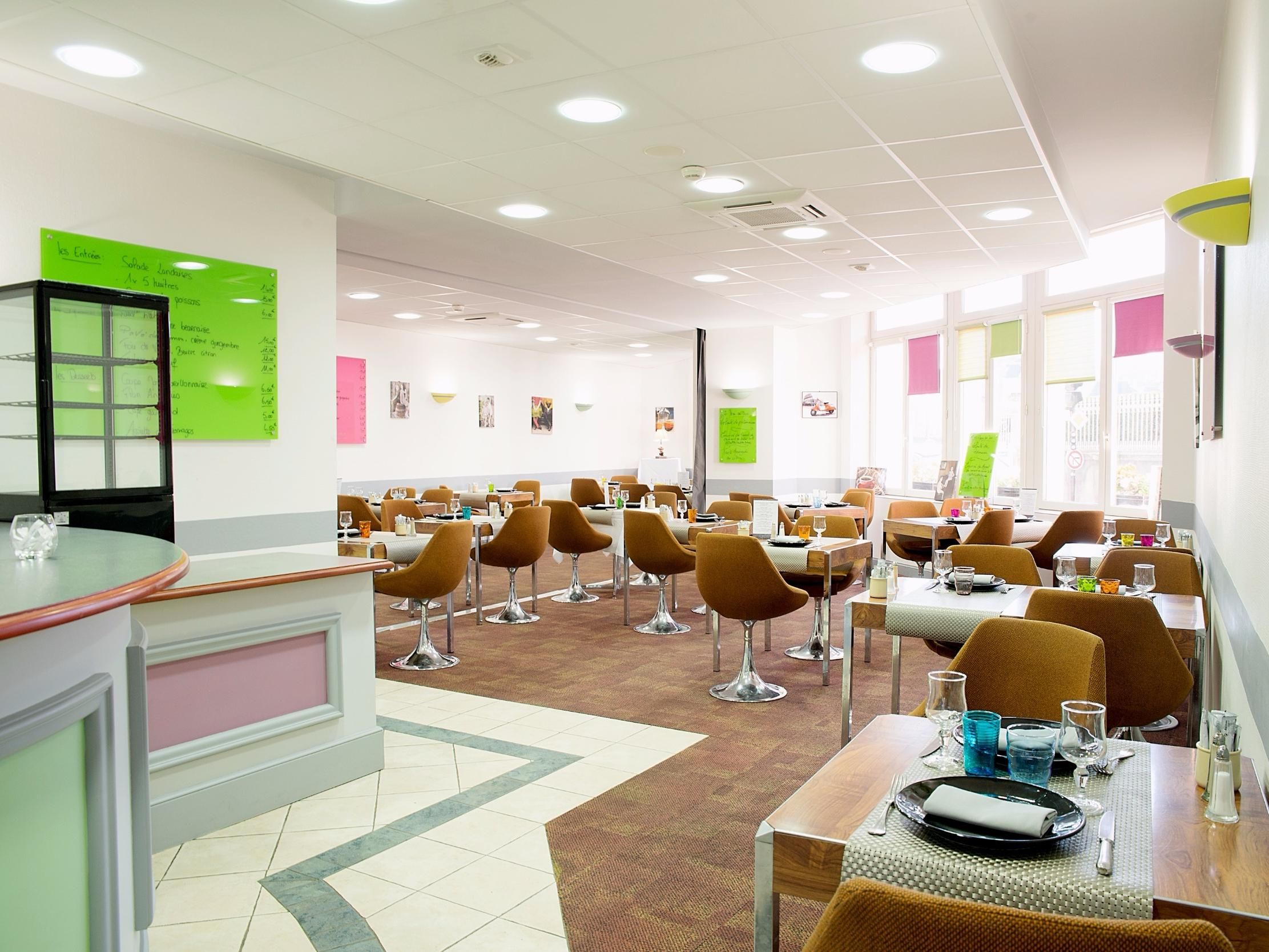 A dining area with tables, chairs, and a counter.